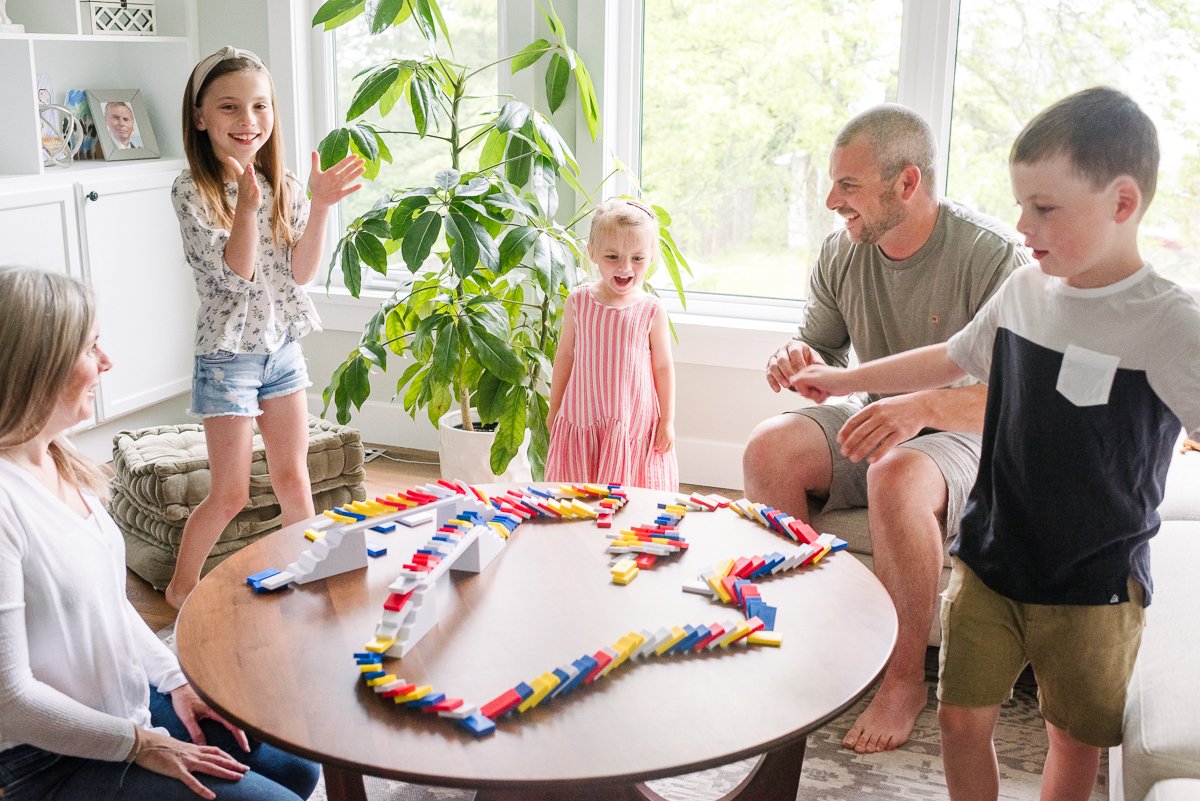 Family enjoying happily setting up dominoes track