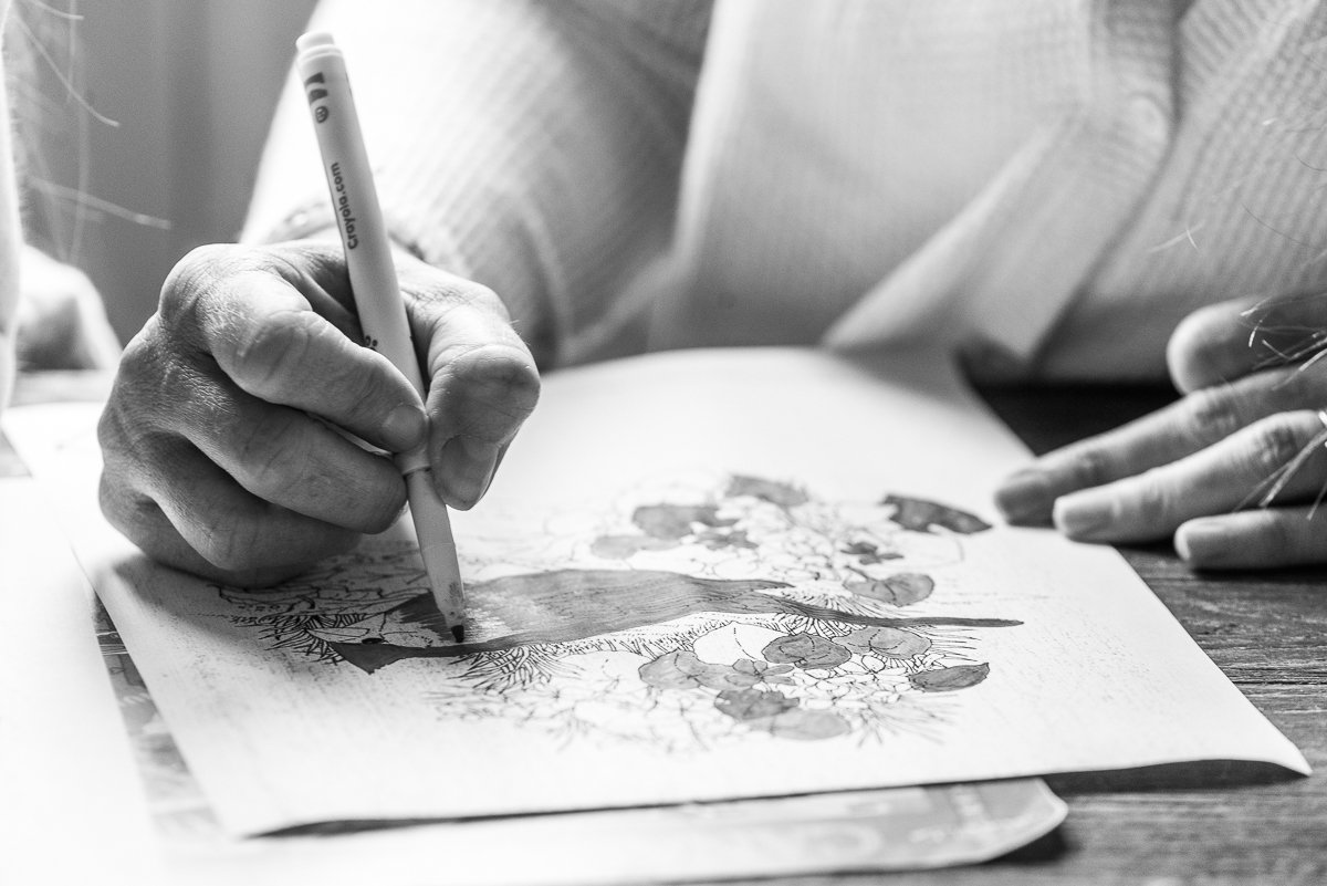 Black and white image of a kid's hand while coloring
