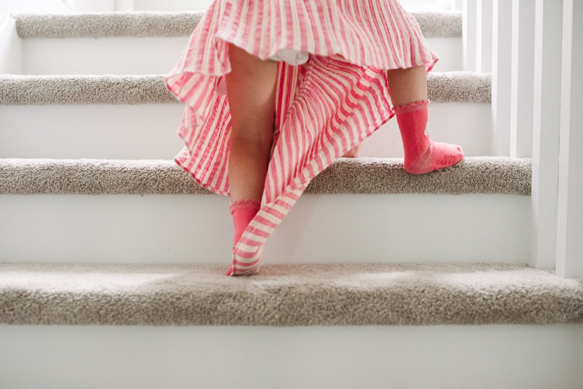 Small girl child walking up the stairs at home