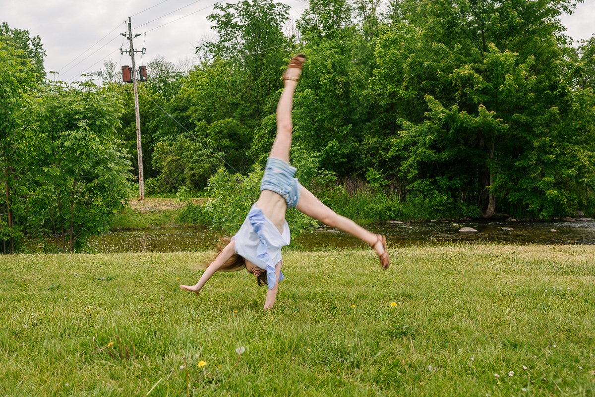 Girl playing in the garden doing cartwheel