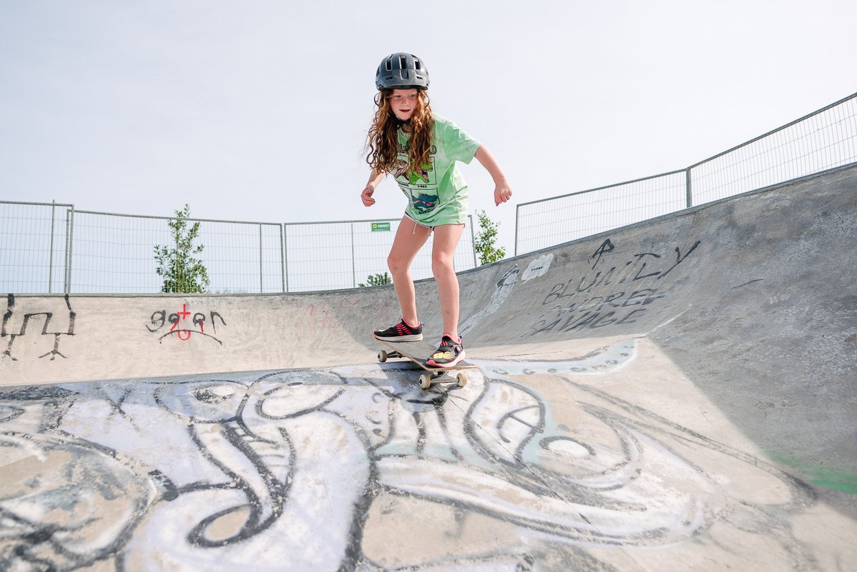 Little girl skateboarding wearing helmet for safety