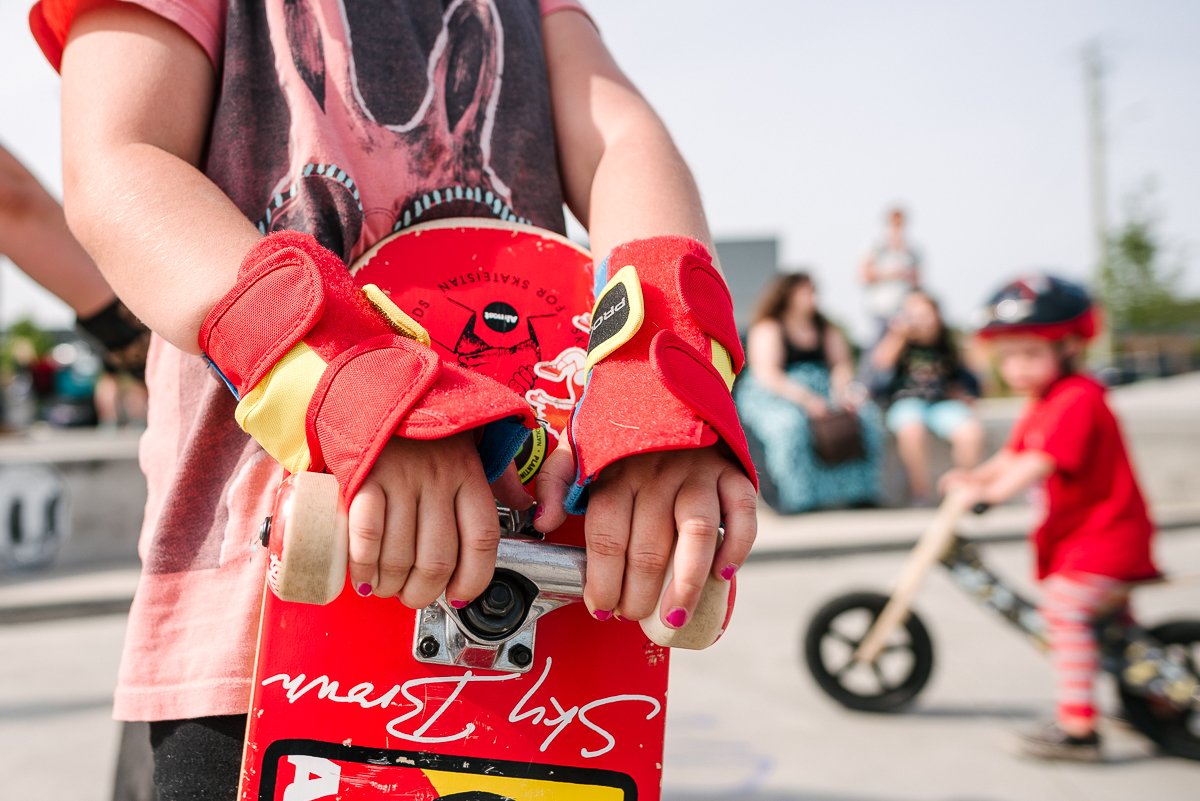 Girl holding red colored skateboard