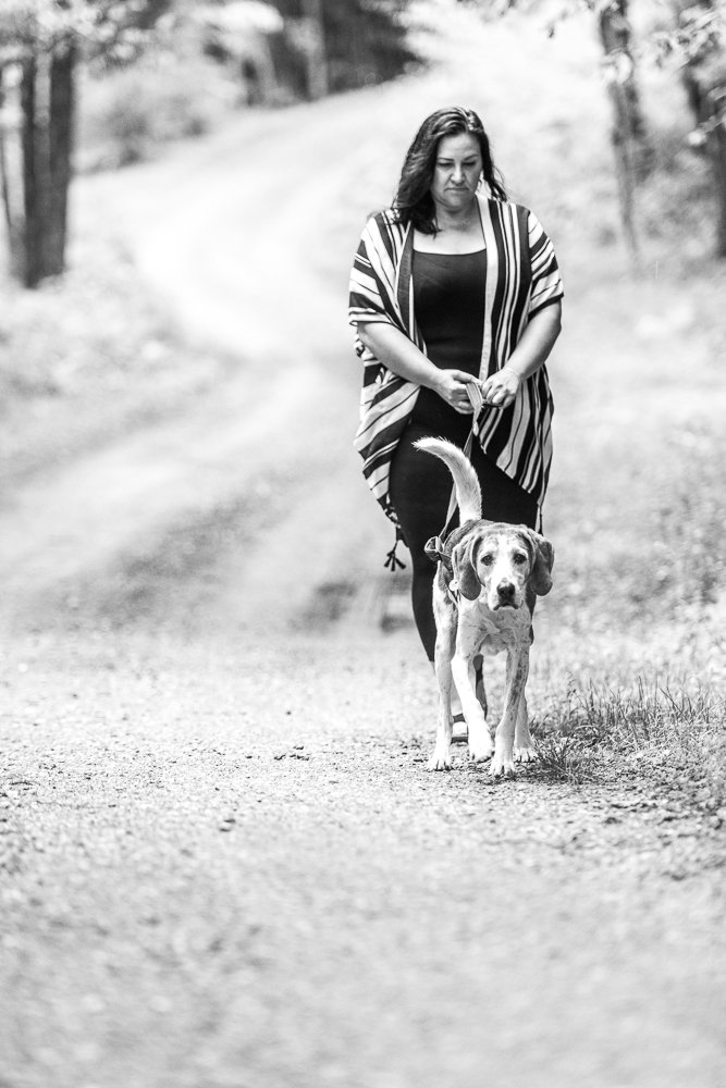 Black and white picture of a dog with his mom walking in the garden.