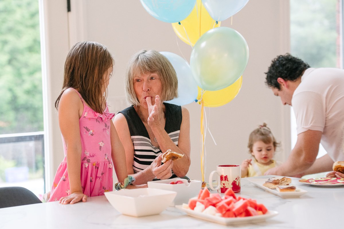 Family celebrating at home with balloons, cake and sweets.