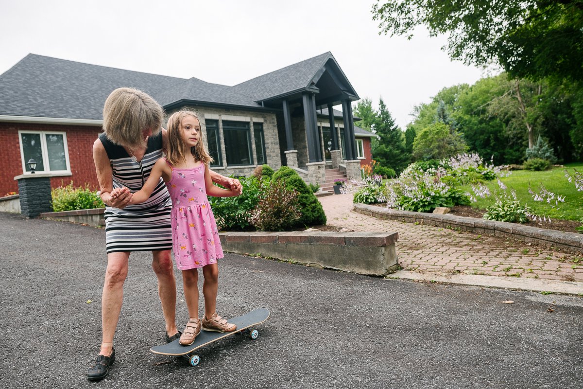 Girl learning to skateboard from her grandma