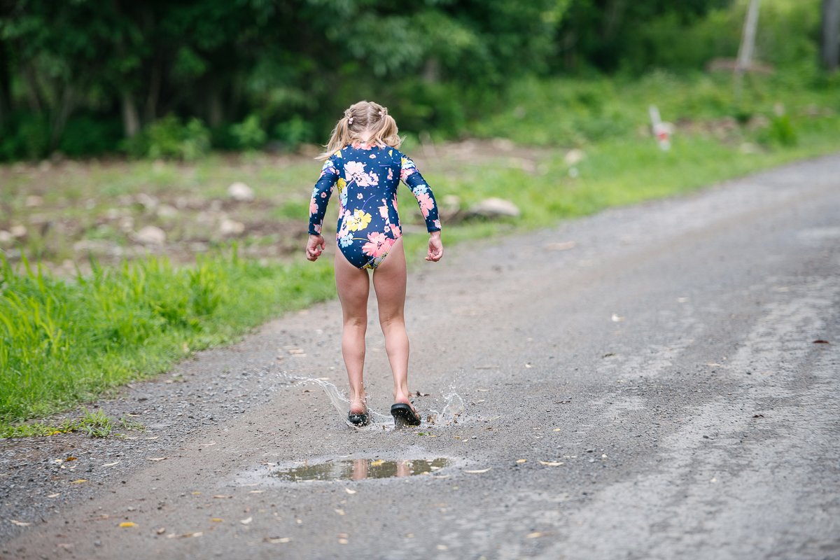 Girl jumping on the street in the standing water