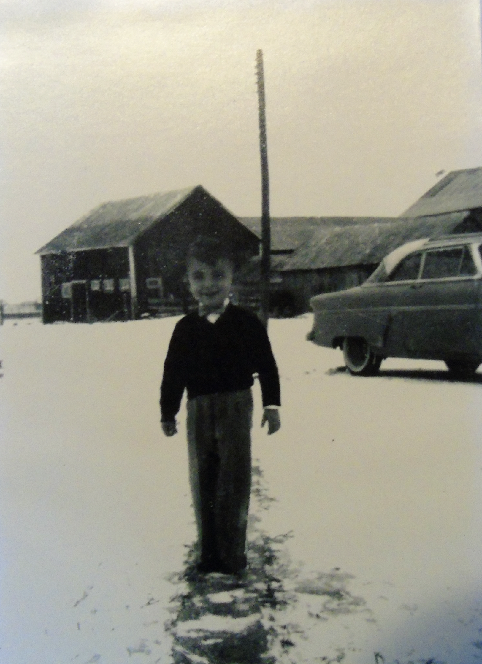 Old pic of a kid standing in front of the garage