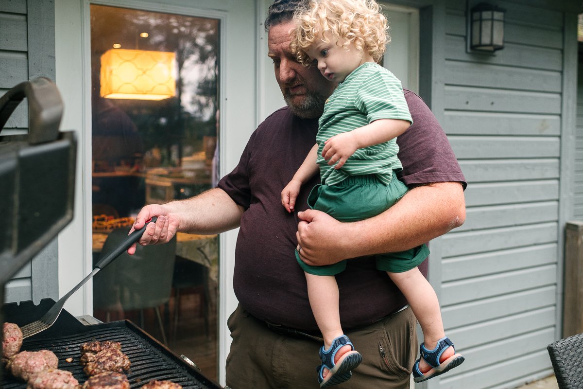 Child in his dad's arm cooking in the kitchen