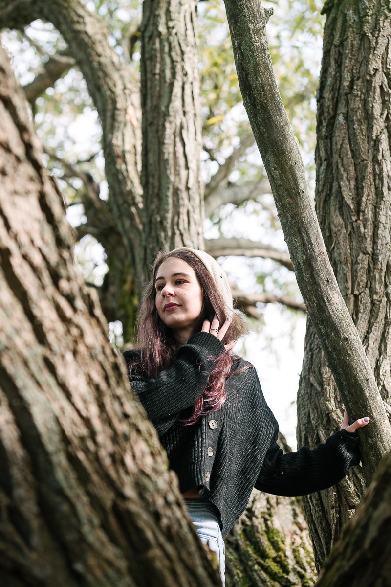 Woman climbing up the tree at the forest