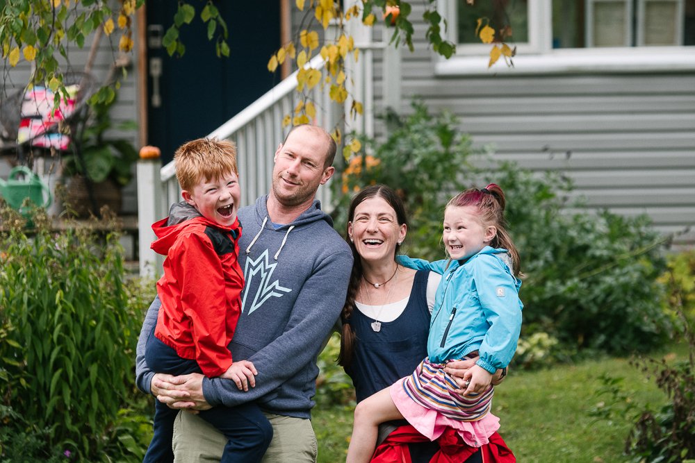 Couple with their two little kids in their arms