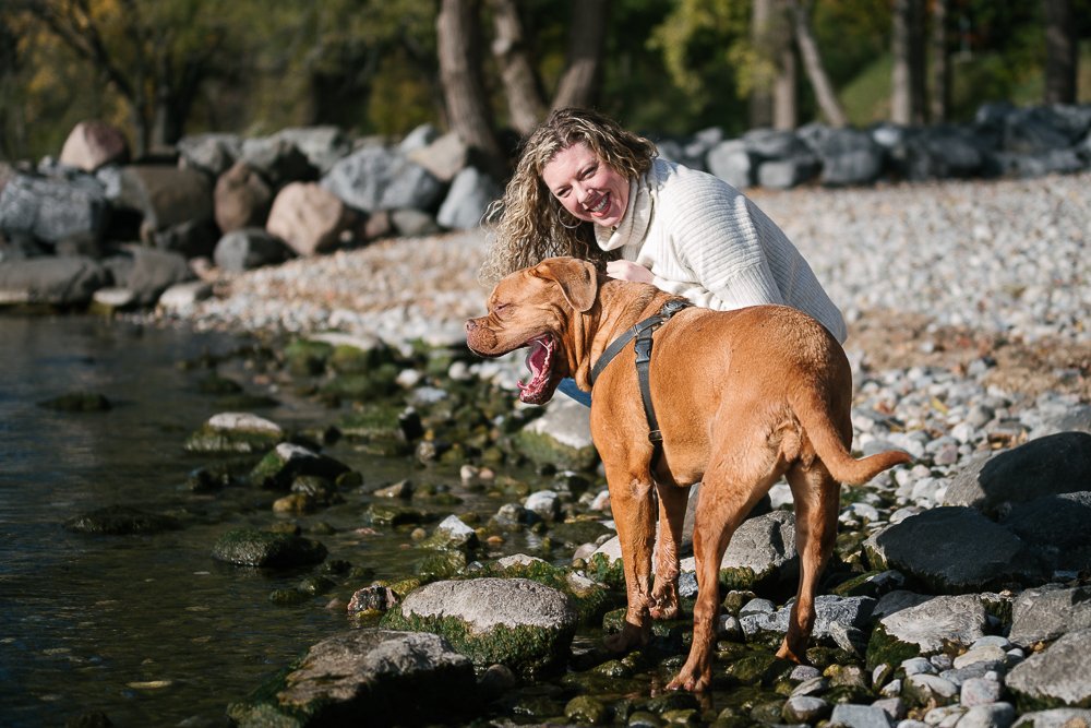 Dog and her mom sitting near the lake in the water.