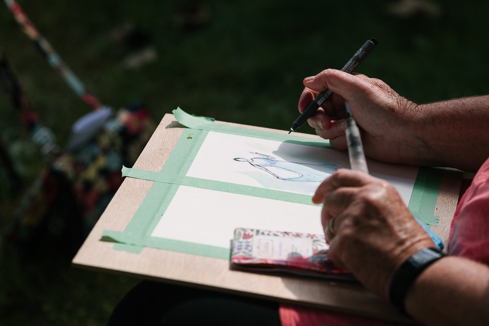 Artist drawing in the outdoor live session.