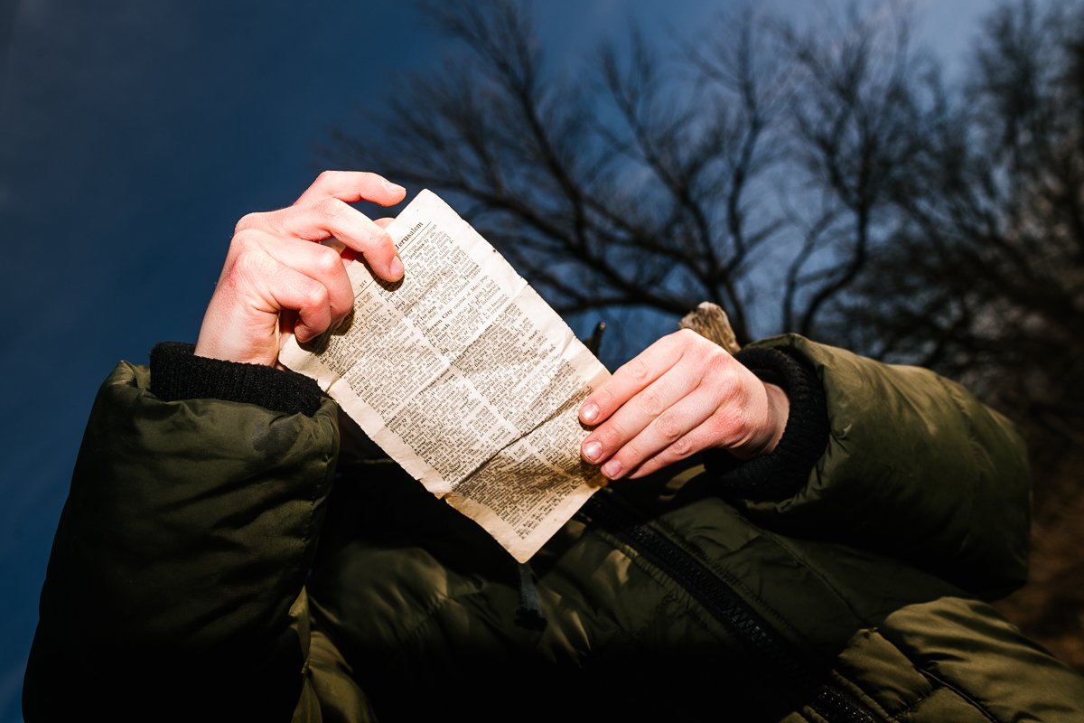 A boy reading a paper while giving a shot