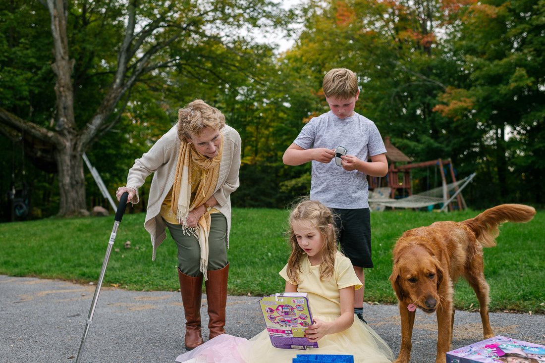 Kids playing with their grandmother and pet dog
