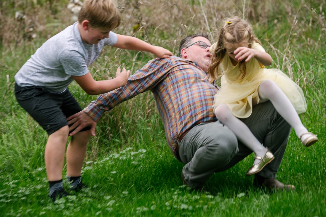 Father playing with his son and daughter in the garden