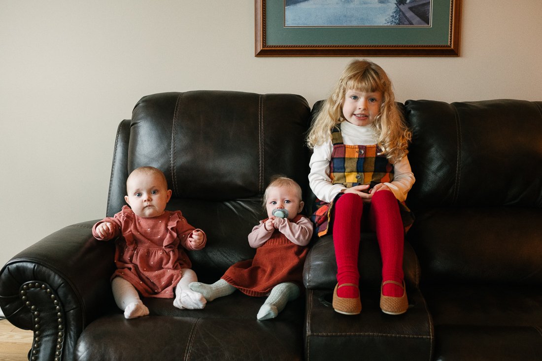 Cute little kids sitting on the sofa in red dress