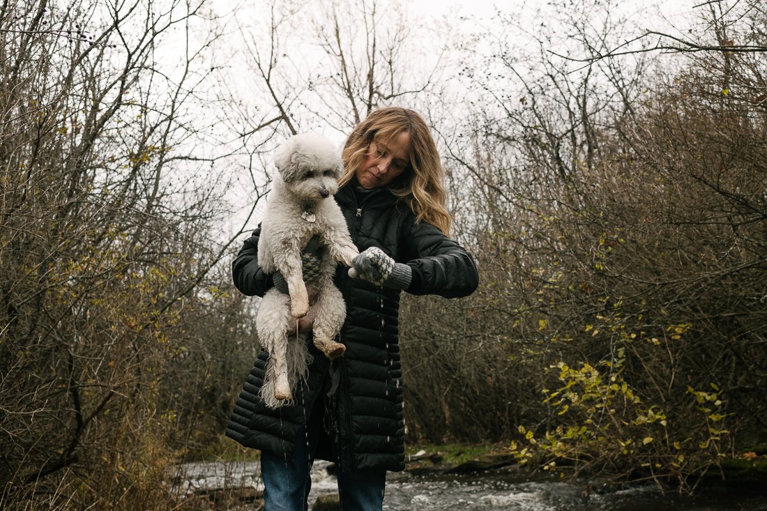 Woman holding her pet dog in arms. 