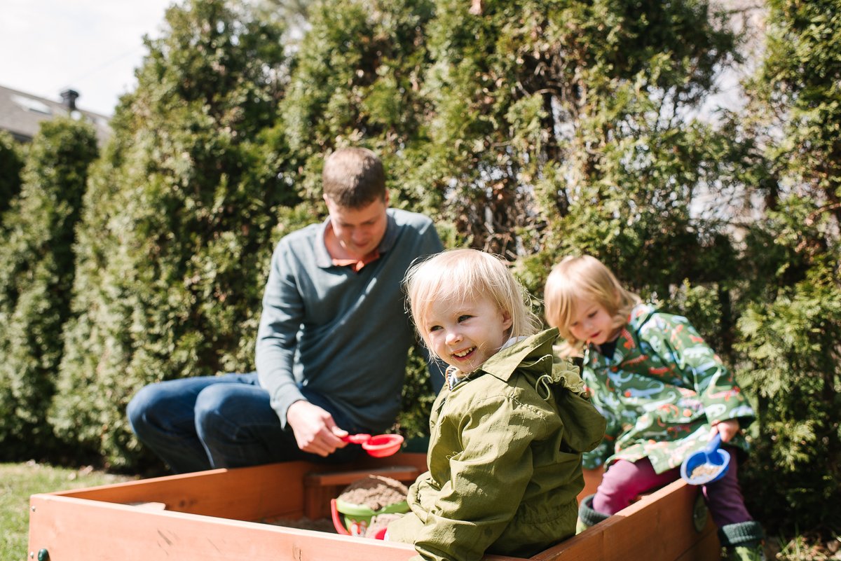 Kids playing in the garden in the sandbox making homes with sand