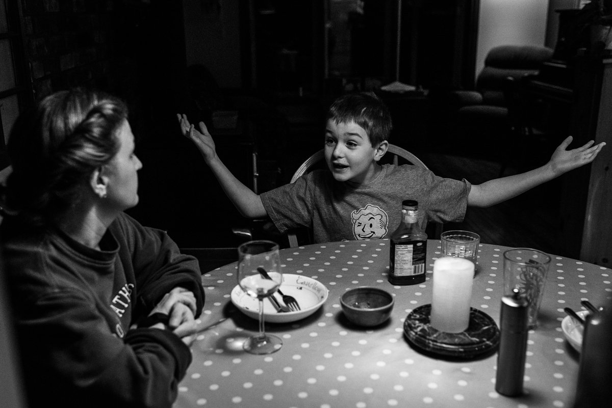 Black and white photo of mom and son discussion during dinner.