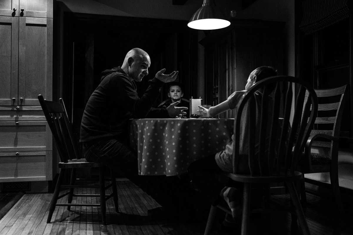 Black and white picture of family having dinner together in dim lights