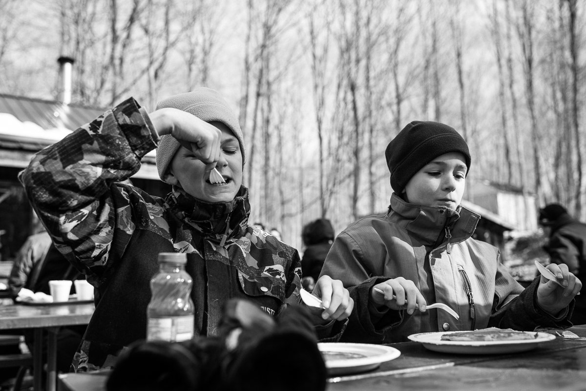 Black and white image of boys eating pancakes.A