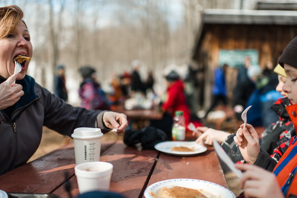 People eating pancakes in the Maple Madness park