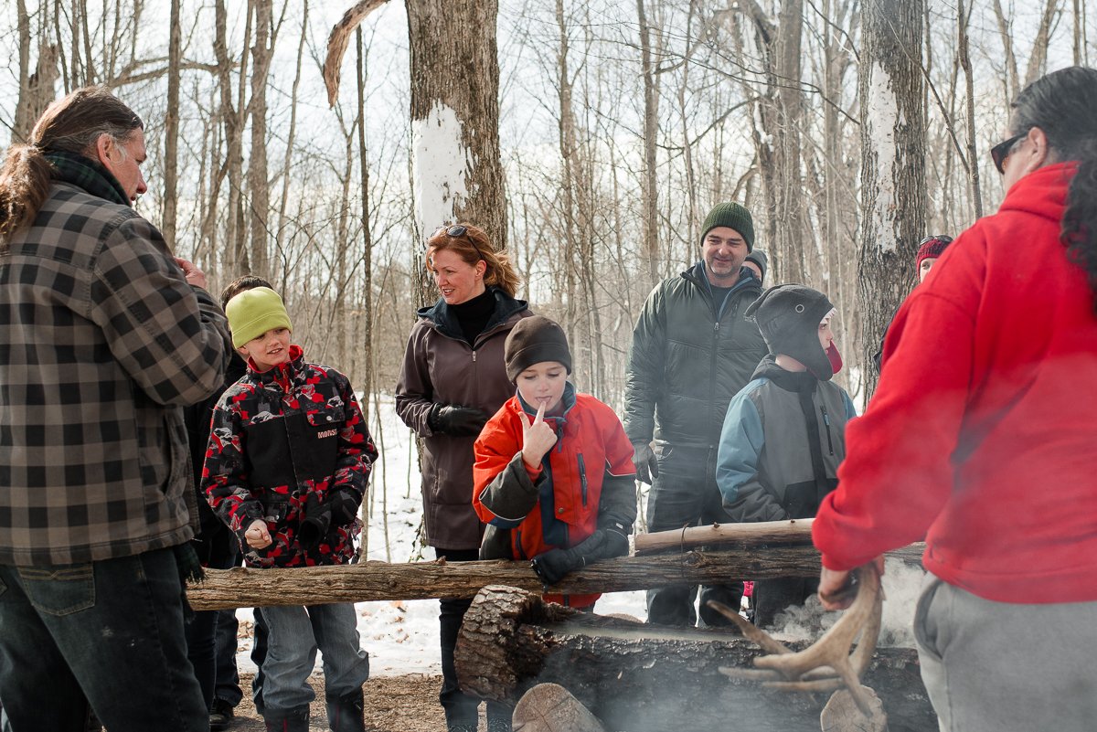 People sitting in the park seeing the making of maple syrup 