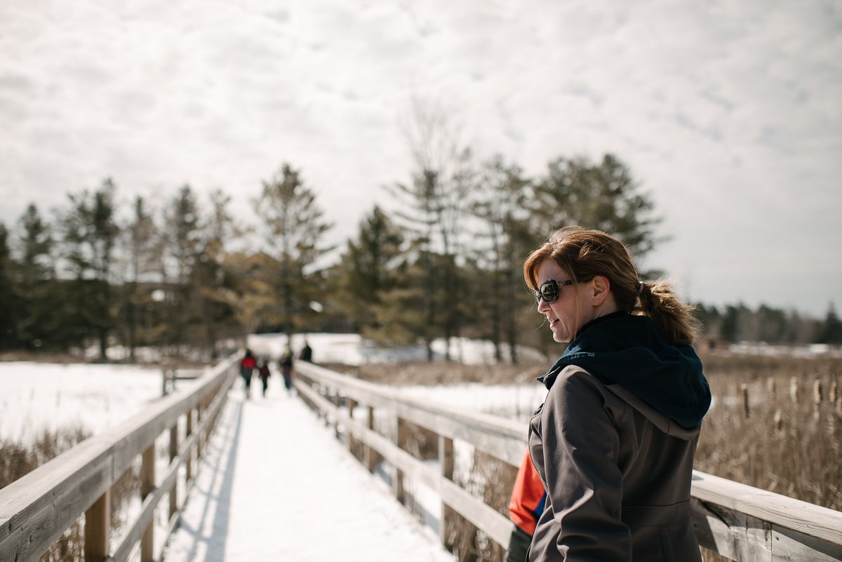 Woman posing in snow at Maple Madness at the Cataraqui Conservation Park. 