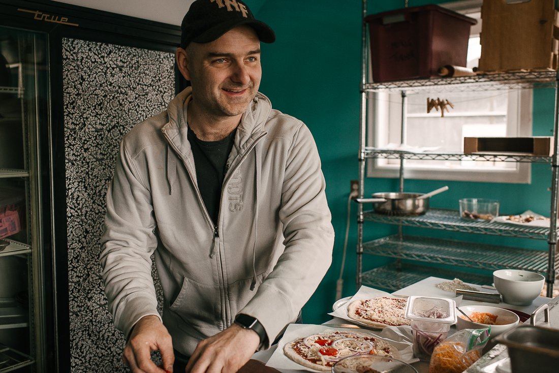 Man preparing pizza for the pizza party in the kitchen.