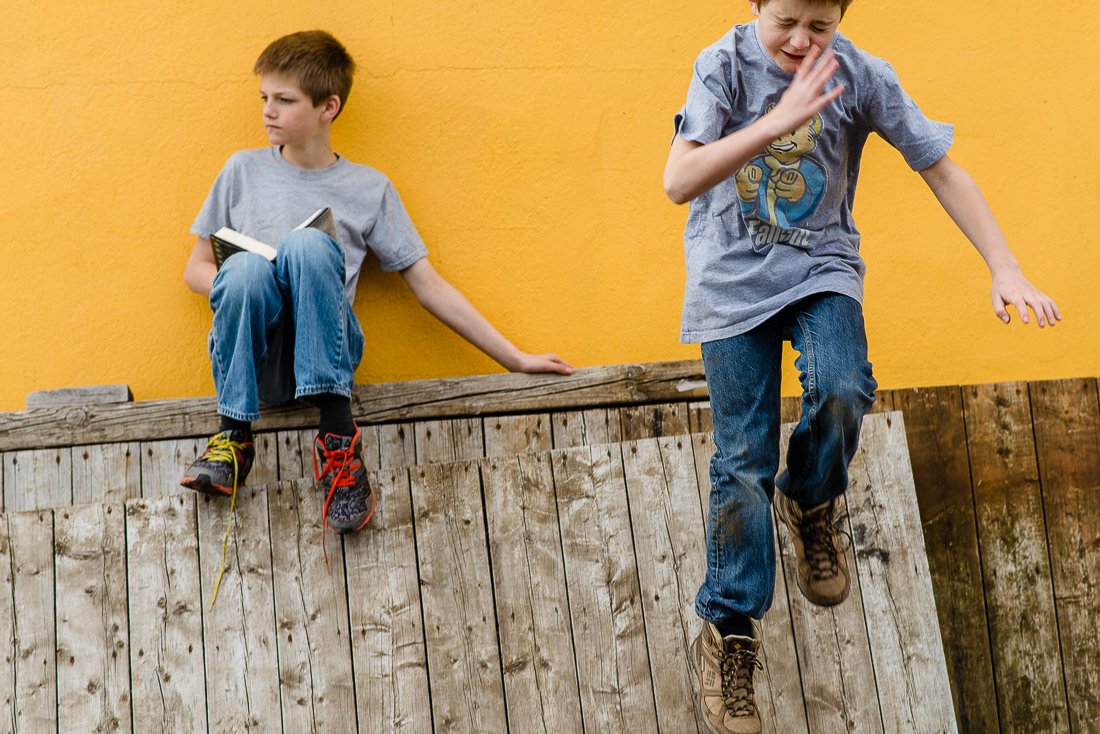 Boys studying and playing on a wooden base on his picnic.