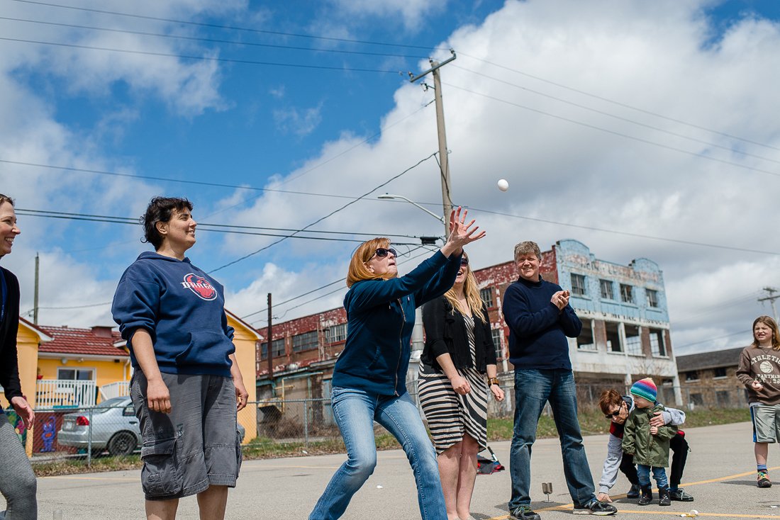 Woman catching egg. Family playing egg toss game on their picnic.