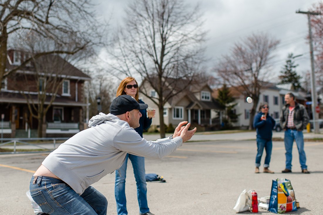  Man catching egg. Family playing egg toss game on their picnic. Family playing egg toss and get together for pizza party. Photography by Viara Mileva Quirky love photography in Kingston, Ontario, Canada. Best Candid wedding engagement family photogr