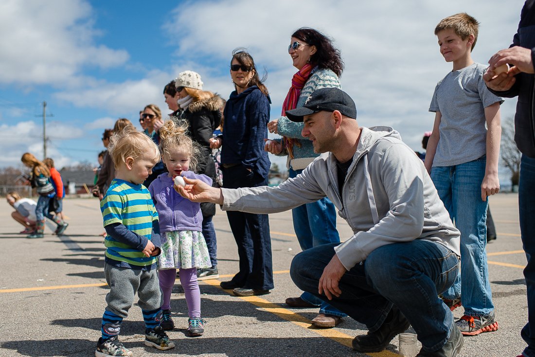 Man offering egg to little kids on the picnic