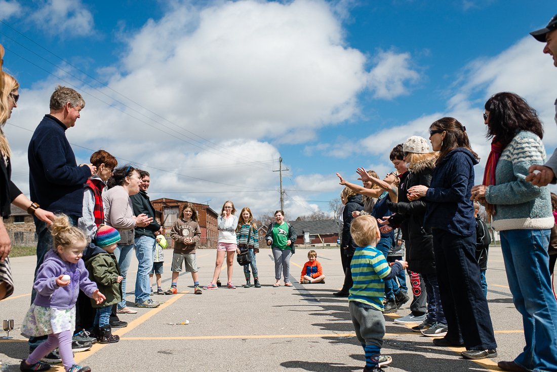 Family and kids lined up in a lane to play egg toss game