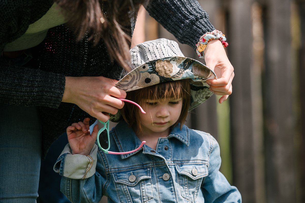 Girl going in the playarea wearing hat and glasses