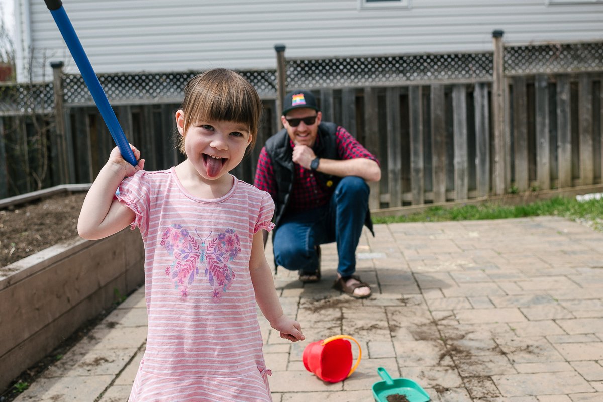 Girl playing in the outdoor with water, bucket, mop