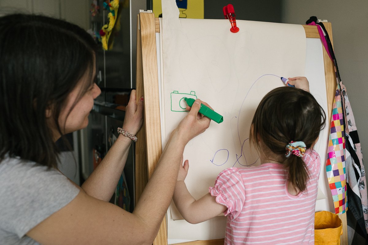 Girl drawing on the board with colour pencil.