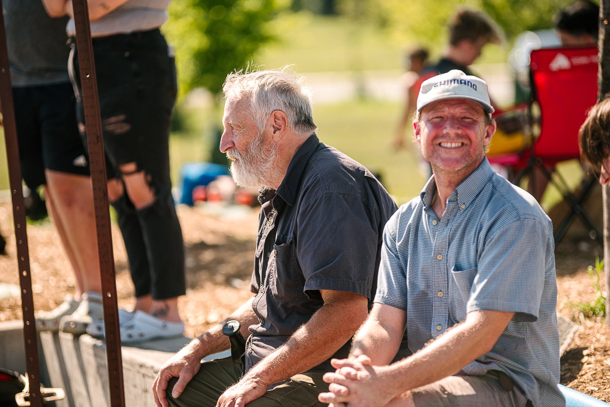 Men seeing skating competition with smile on face.