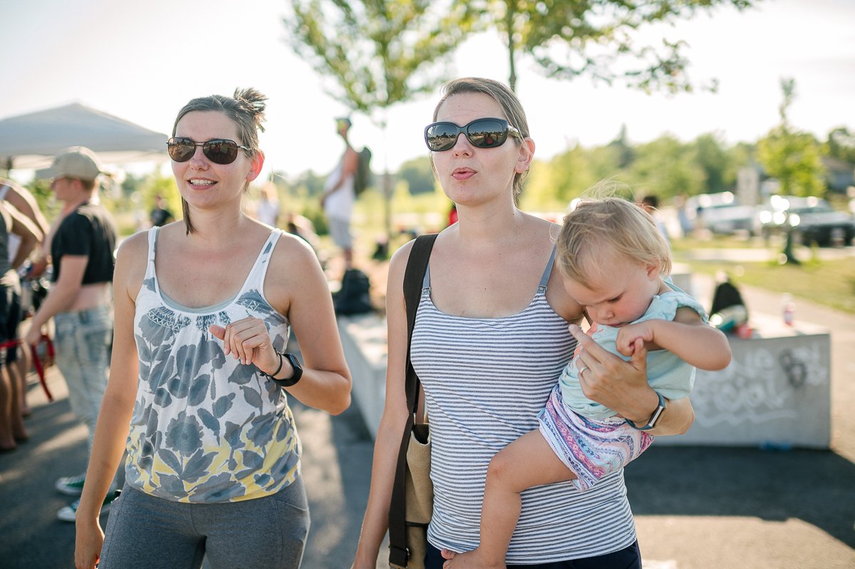 Women watching the skating event with a little baby.