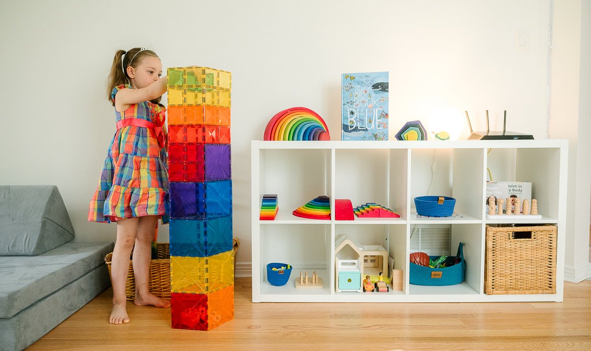 Girl making toy tower building