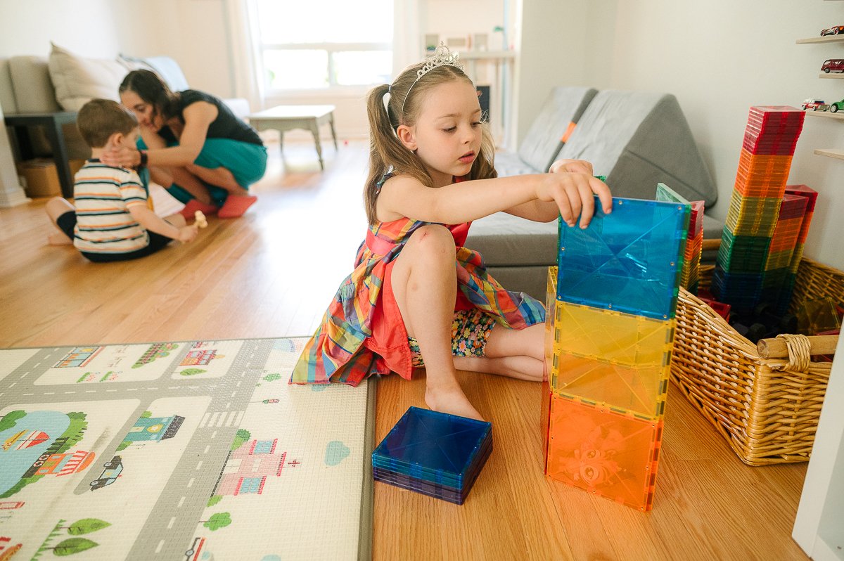 Girl making toy tower building