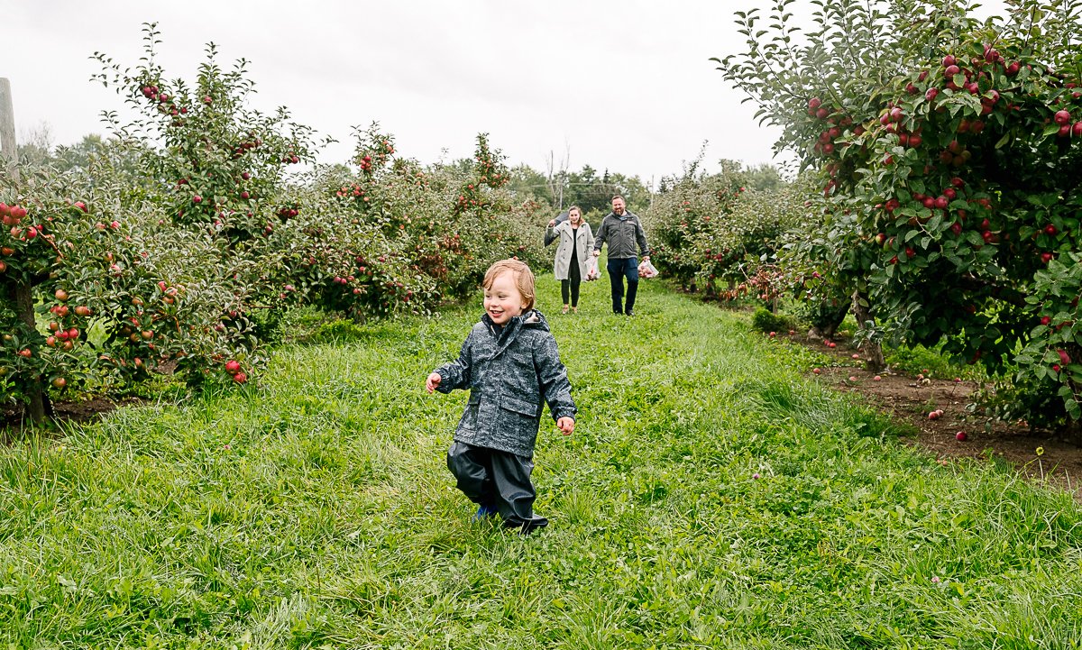 Boy running in the grass in the apple farm