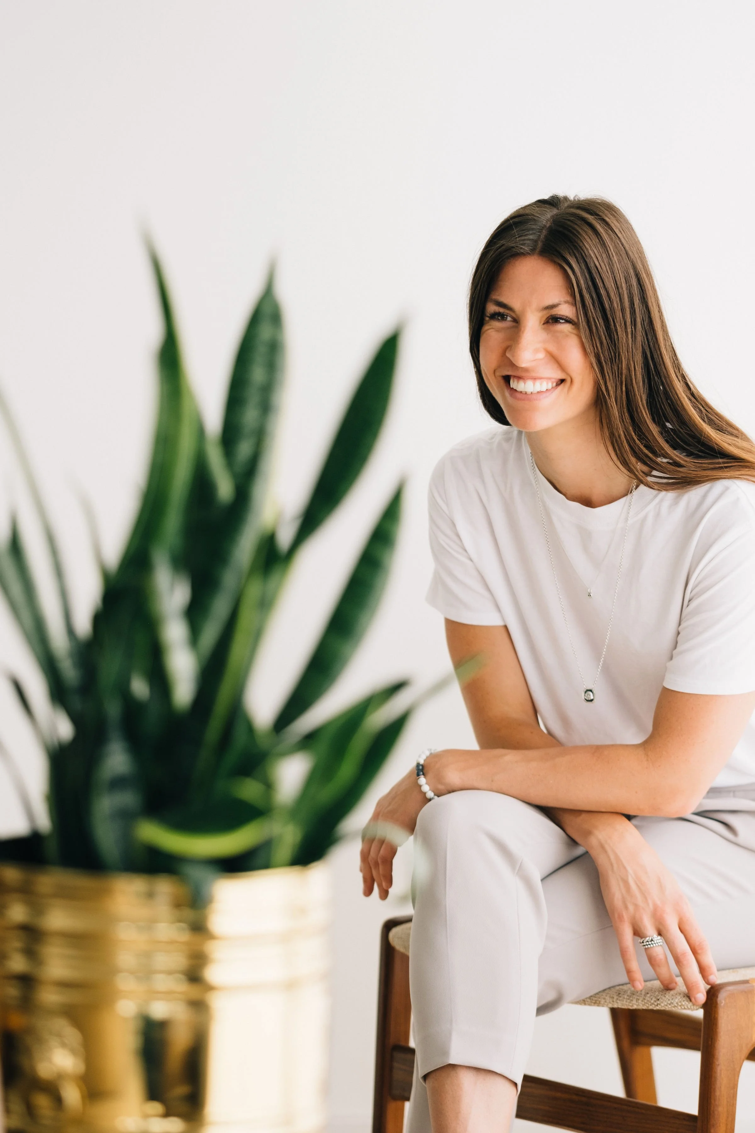 nutritionist sitting with a snake plant ready to help you with gut and hormone health