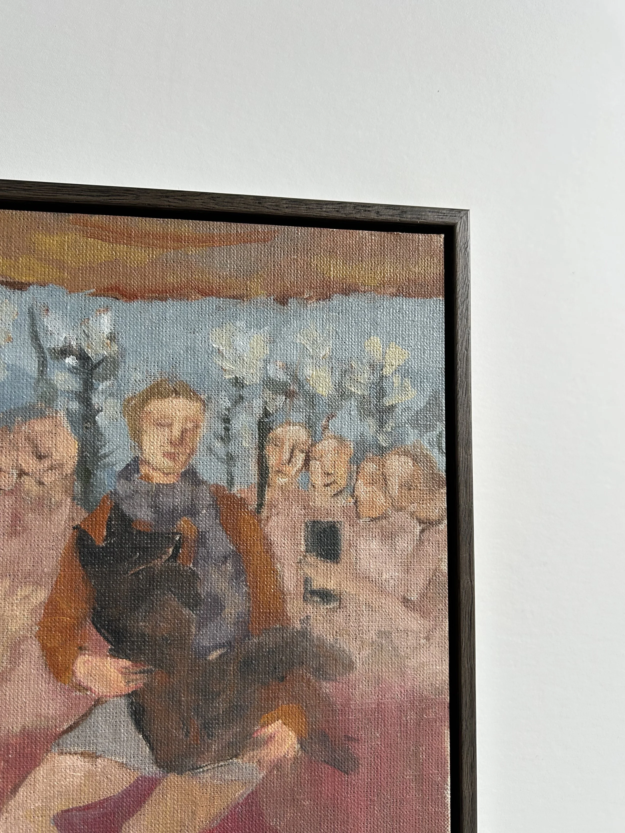 Person holding a framed painting. The background includes muted, abstract colors and a metal shutter.