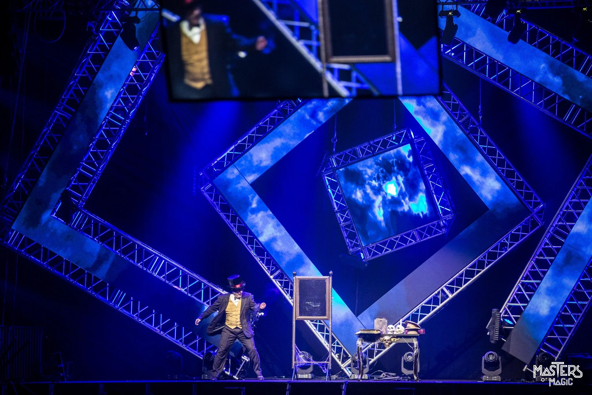 Stuart MacDonald performing his Mirror Act on the blue-lit Masters of Magic stage at Venaria Reale near Turin, Italy