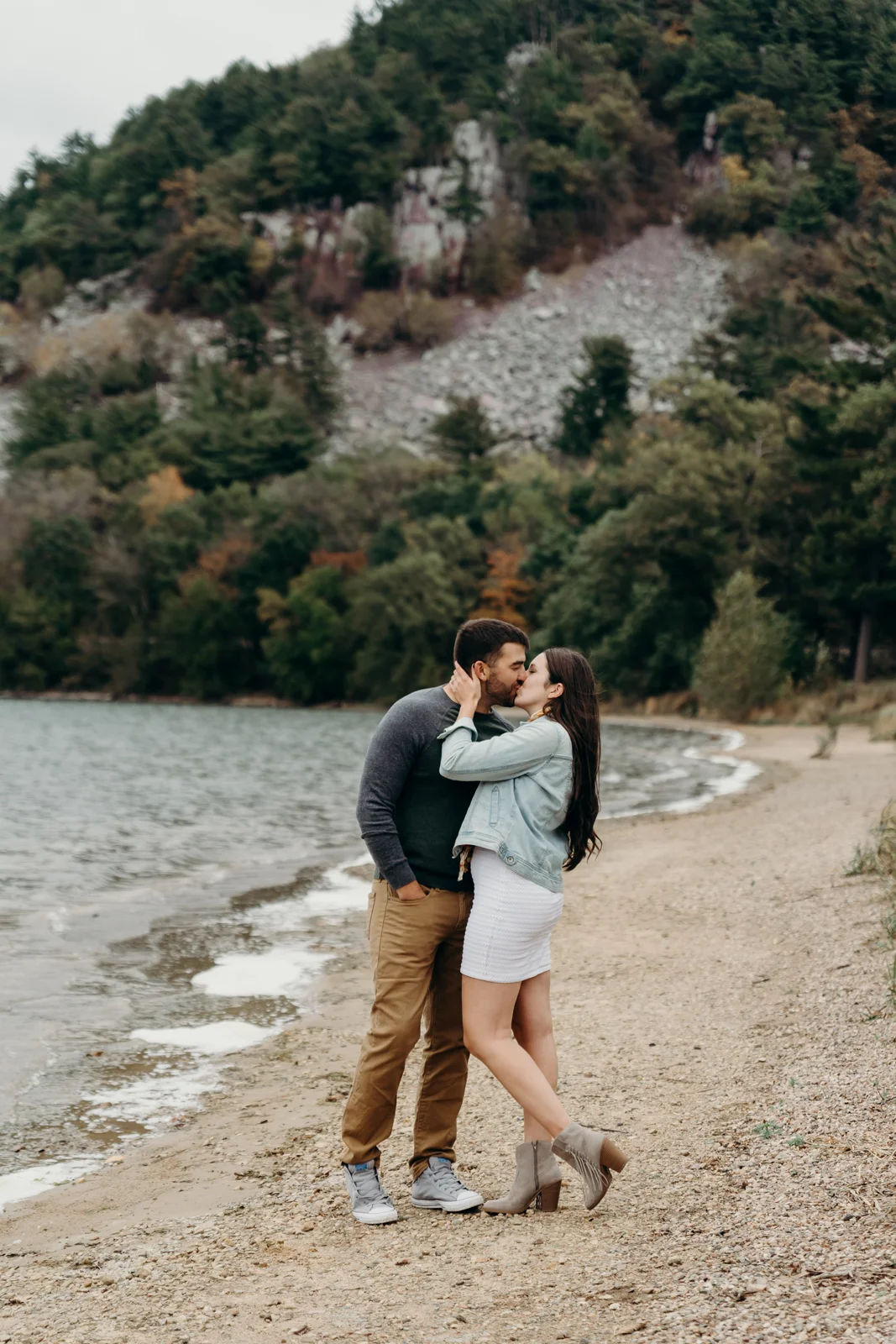 Engaged couple kisses each other at Devil's Lake State Park.