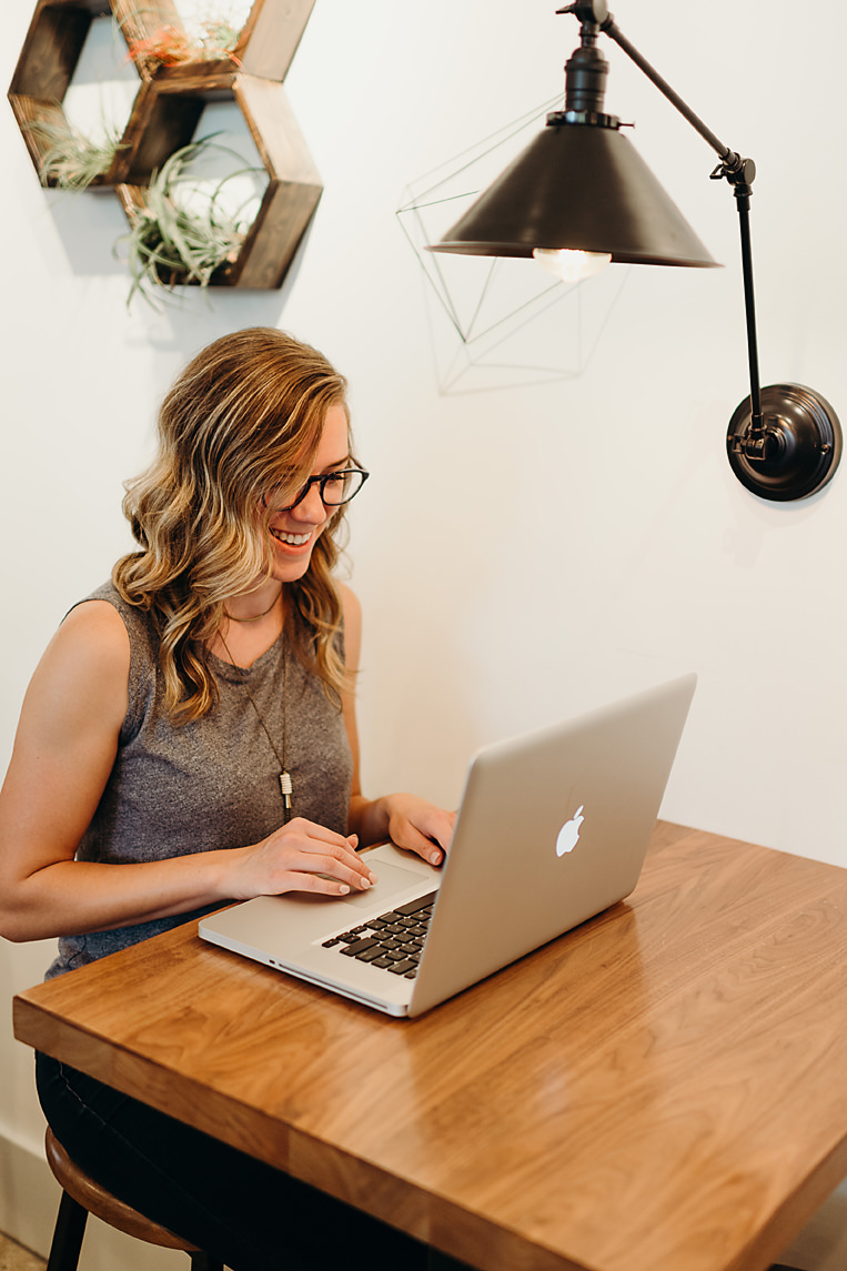 Graphic designer smiling and working on MacBook