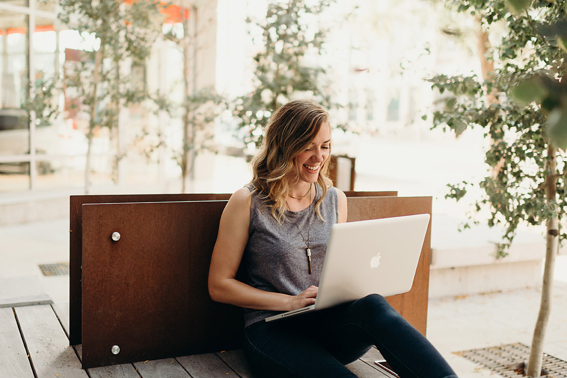 Graphic designer smiles while working outside