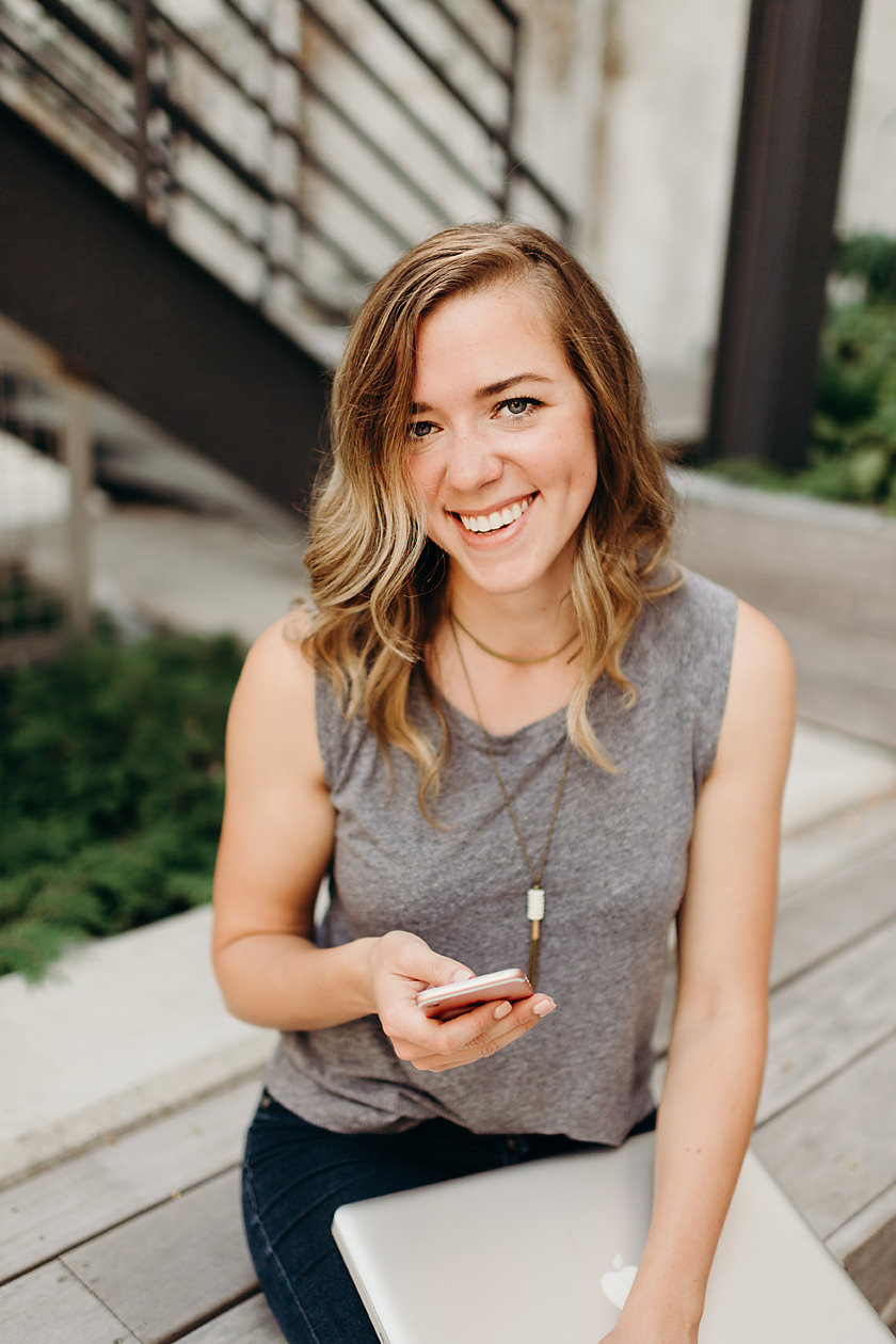 Graphic designer smiling with phone in hand