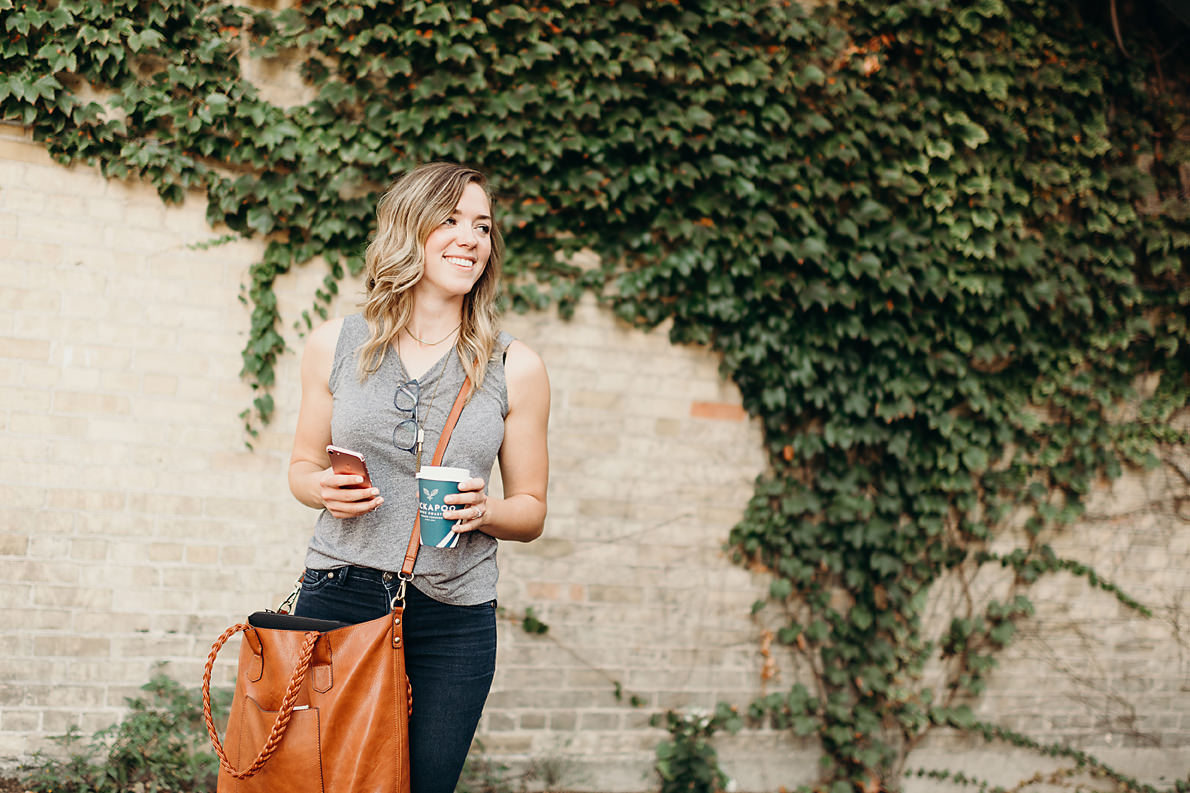 Busy small business owner holding phone and coffee